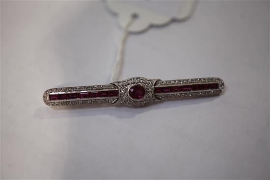 A mid 20th century white gold, ruby and diamond encrusted bar brooch, 61mm.